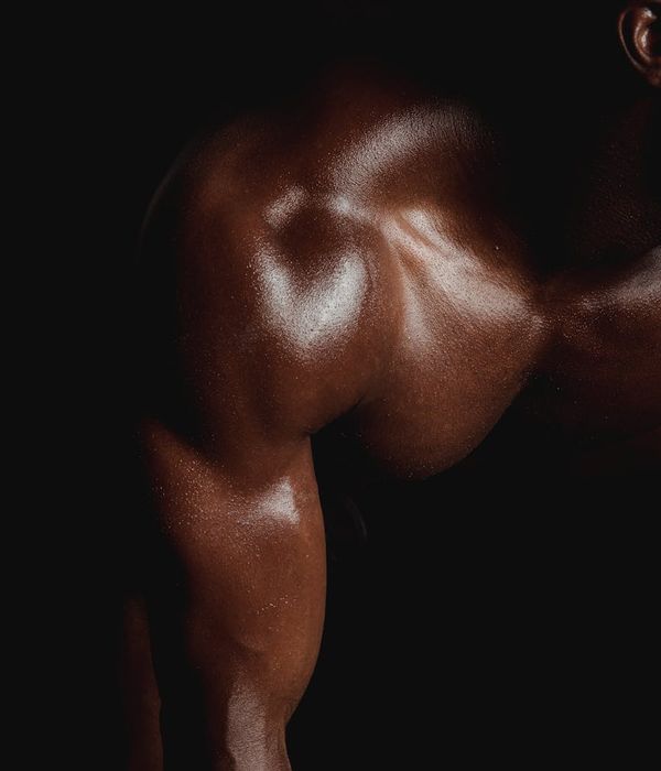 Man performing a controlled strength exercise in a minimalist dark gym.
